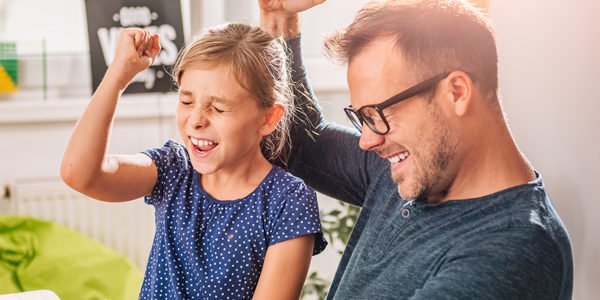 Father And Daughter Cheering during playing game on tablet