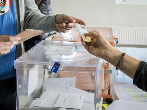 Un votante entrega su DNI en una mesa electoral